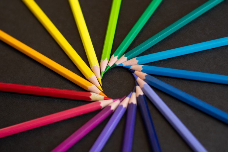 Buntstifte in allen Farben des Regenbogens bilden einen strahlenden Kreis